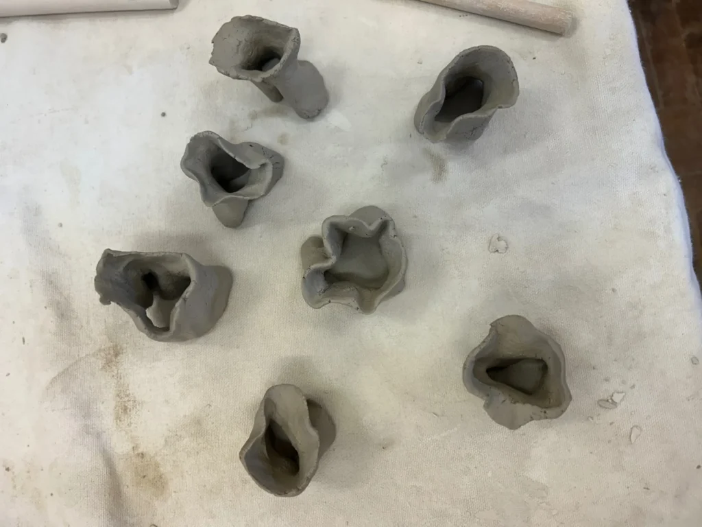 Multiple organic clay rings on table in studio.